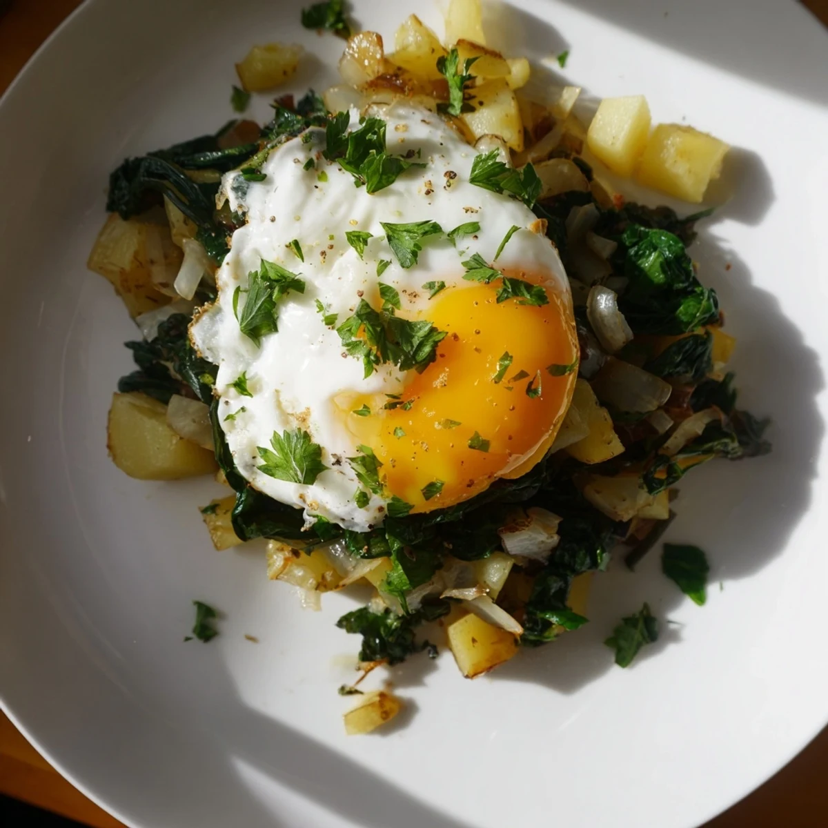 Golden, crispy Spinach and Potato Skillet, topped with a runny fried egg ready to eat.