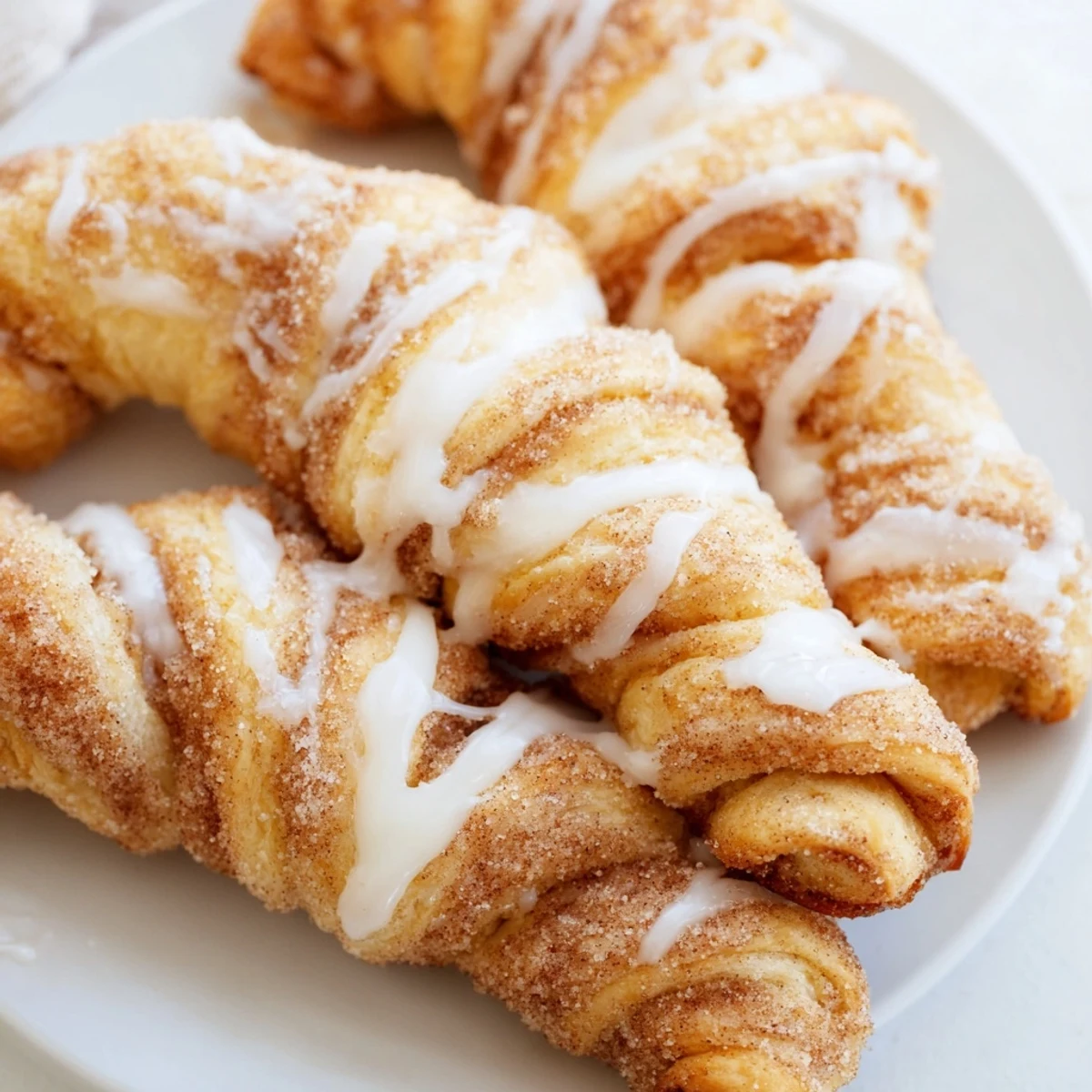 Golden Air-Fryer Cinnamon Roll Twists, drizzled with sweet glaze, a perfect, warm breakfast pastry.