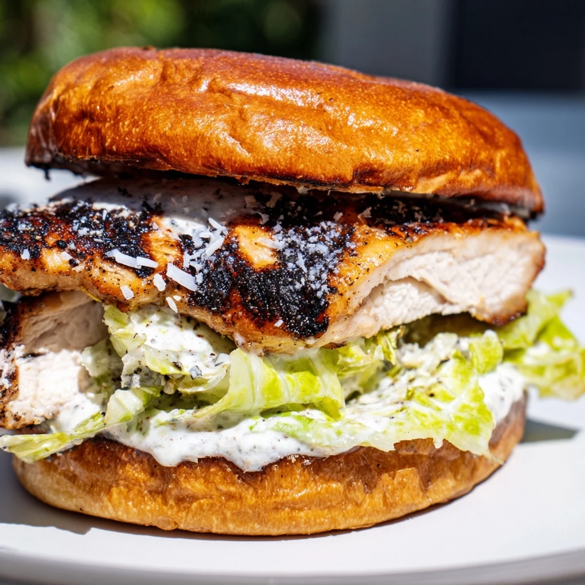 Saftiges Caesar Chicken Sandwich mit knusprigem Salat und Parmesan auf golden getoastetem Brioche.