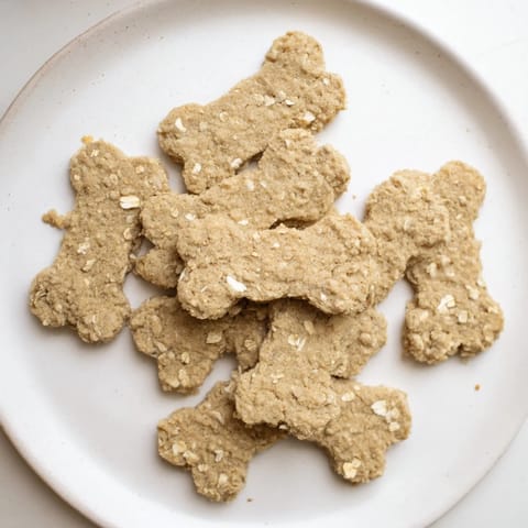 Golden, baked Pawsitively Good Dog Bone Treats ready to be enjoyed by a happy pup.