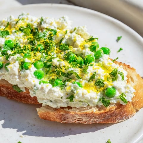 Vibrant Pea & Mint Ricotta Toast with creamy whipped ricotta and fresh mint on golden sourdough slices.