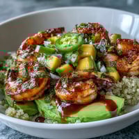 Zesty Mango Salsa and grilled shrimp on creamy avocado with lime chili sauce and quinoa.
